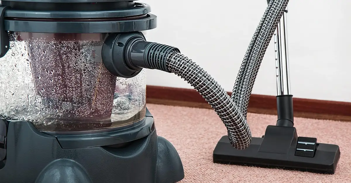 wet/dry carpet cleaning machine with hose attachment on carpet