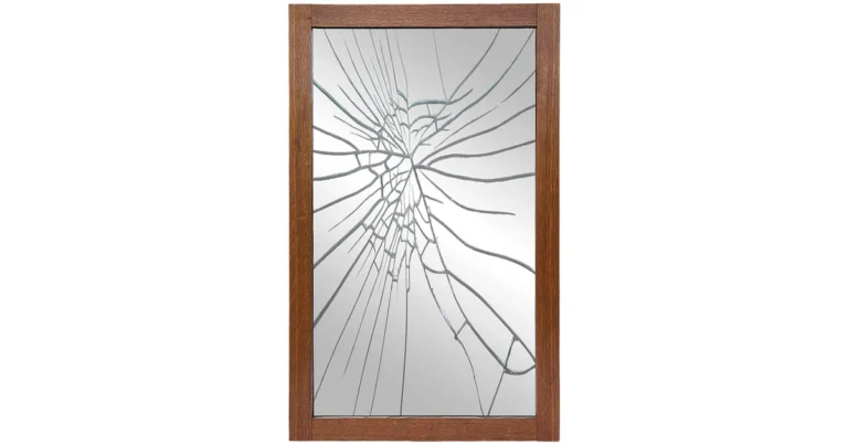 Broken wall mirror in a wood frame with a spiderweb crack pattern