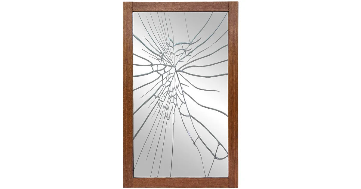 Broken wall mirror in a wood frame with a spiderweb crack pattern