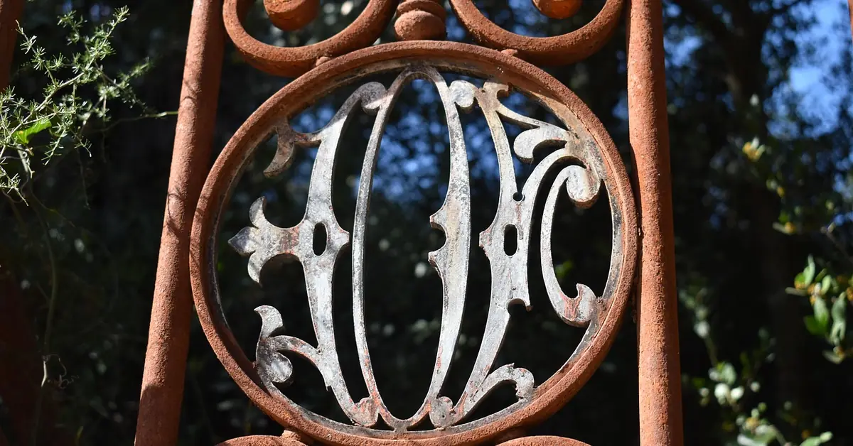 rusted wrought iron gate detail with ornate scrollwork before restoration