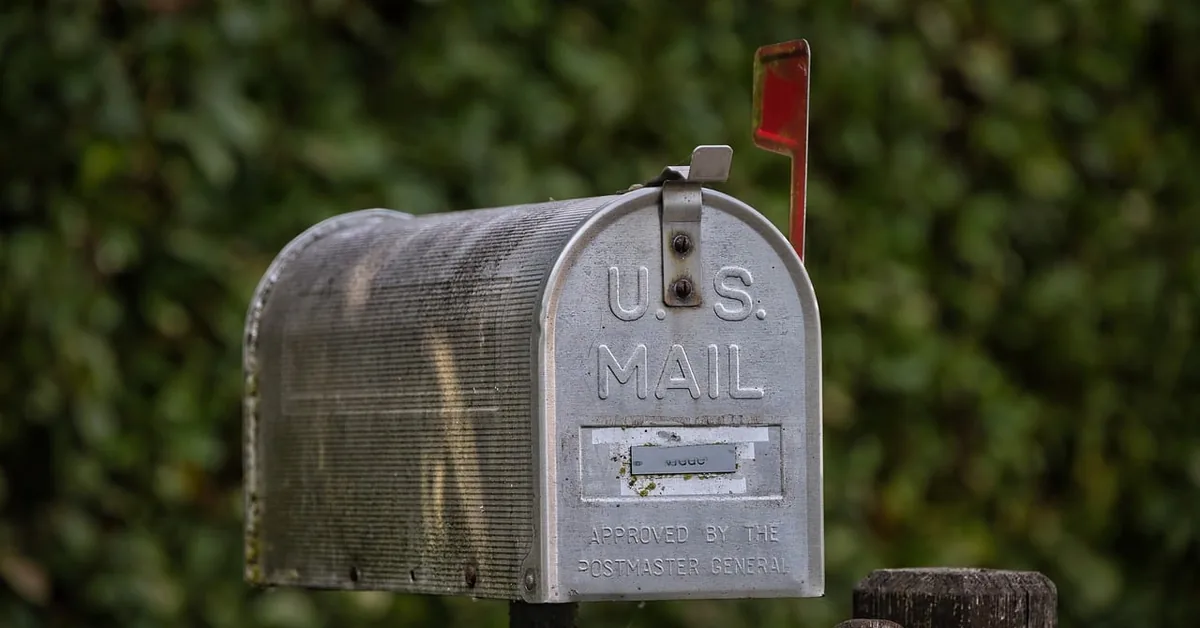 classic U.S. Mail metal mailbox mounted on a post, the type of residential mailbox that uses a replaceable keyed lock