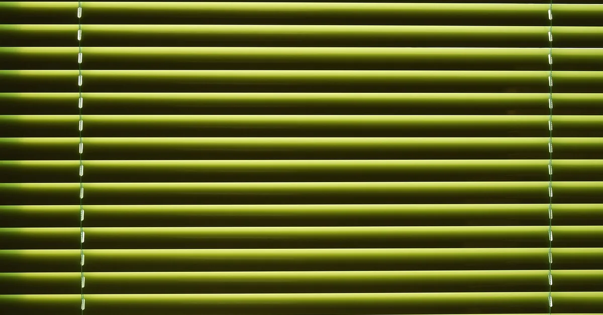 close-up of venetian blind slats letting in horizontal bands of daylight