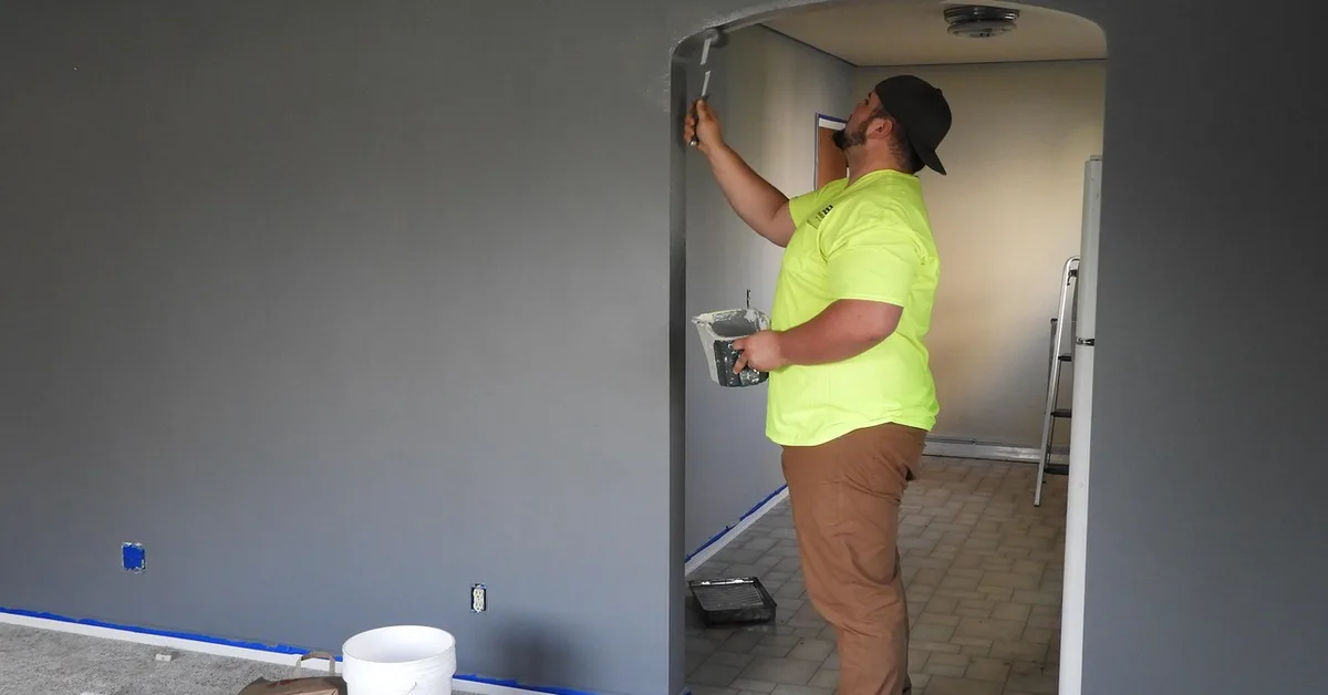Painter using a roller to estimate and apply wall paint
