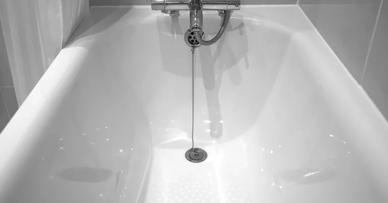 white porcelain bathtub with chrome faucet before repainting