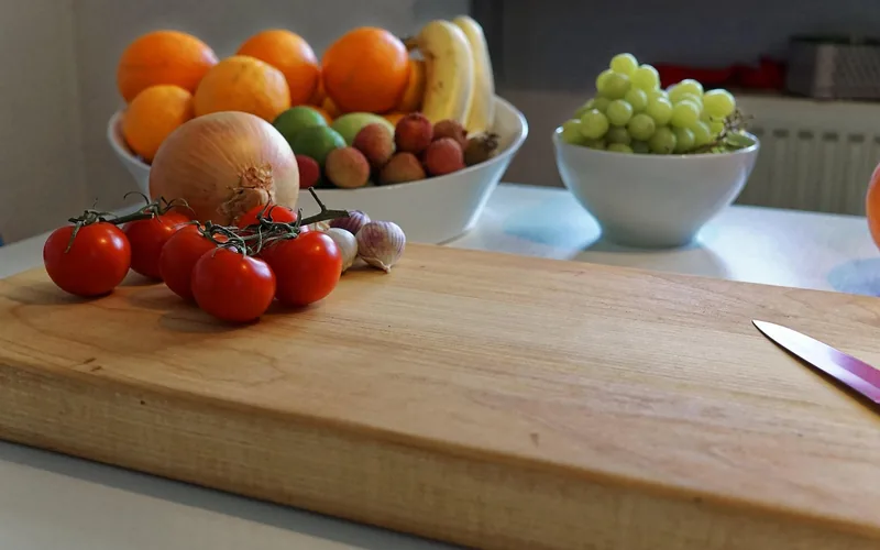 wooden cutting board on a kitchen counter, the type of food-contact surface that needs a non-rancid oil