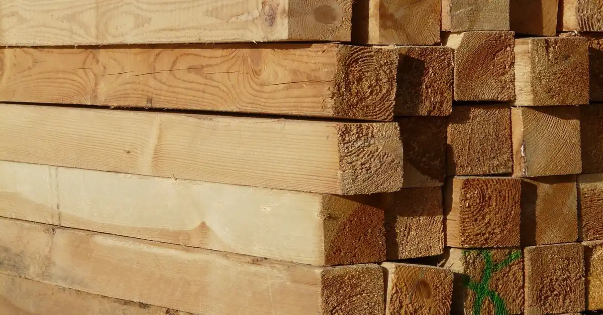 close-up of stacked dimensional lumber boards with cut ends showing grain and grading marks