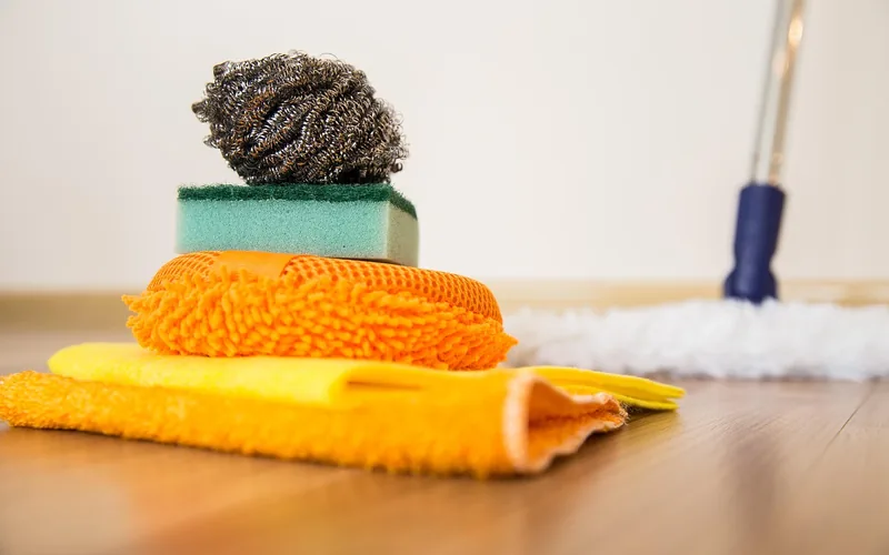 microfiber cloths, a sponge, and a mop laid out for cleaning a laminate floor microfiber cloths, a sponge, and a mop laid out for cleaning a laminate floor