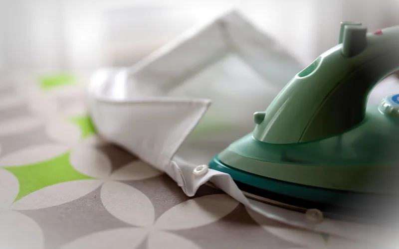 a household clothes iron used with a cloth to melt and lift wax with heat