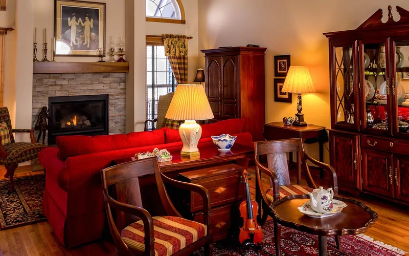 Patterned area rug on a hardwood floor pinned in place by armchairs and a side table