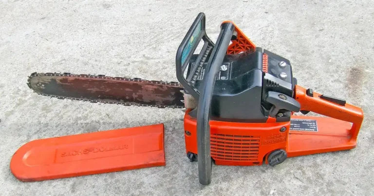 orange gas chainsaw engine housing prepared for fuel line maintenance on a workbench
