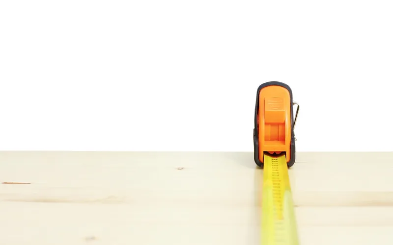 tape measure held against a wooden board for a home improvement project