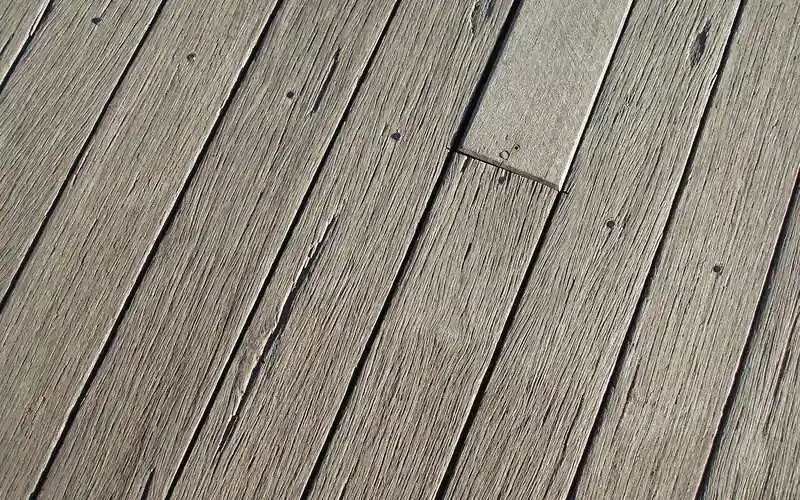 close-up of weathered deck boards showing the narrow gaps between each plank