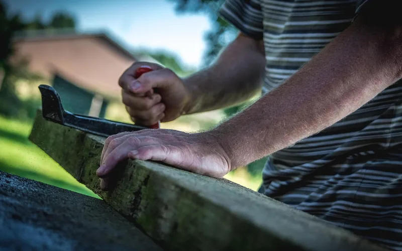hands working on a rough wood board before sealing in a home workshop hands working on a rough wood board before sealing in a home workshop