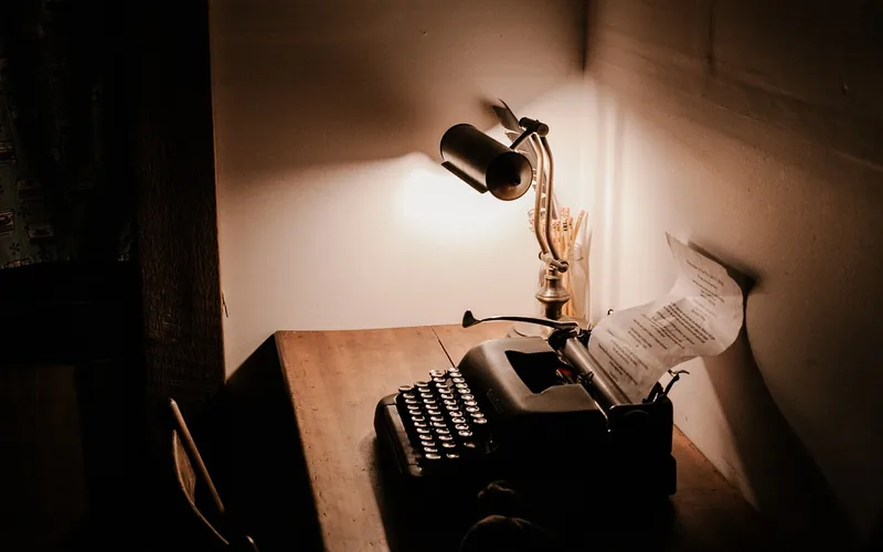 desk lamp lighting a study desk in a room with minimal natural sunlight