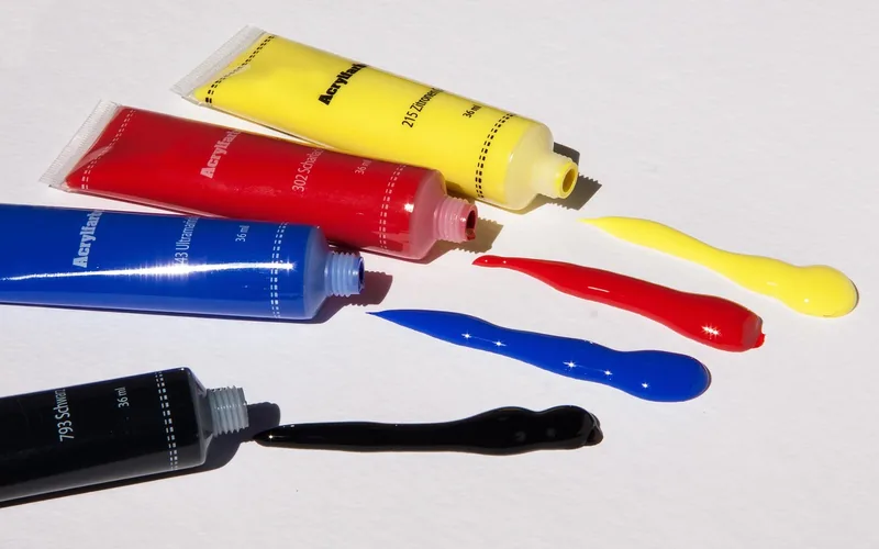 red, blue, yellow and black acrylic paint tubes used for color mixing