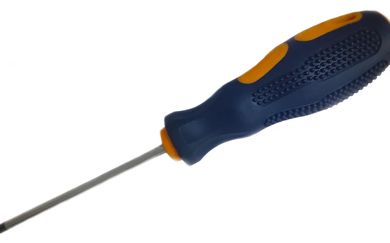 screwdriver tightening a door hinge screw to fix a misaligned frame