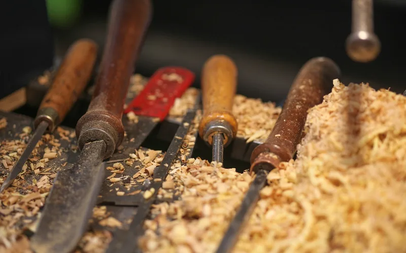 carving chisels and wood chips laid out on a workshop bench carving chisels and wood chips laid out on a workshop bench