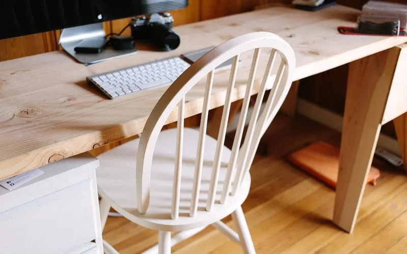 computer monitor and keyboard set on a natural pine wood desk in a home office