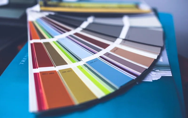 Fanned-out paint color swatch deck showing warm and cool paint chips side by side Fanned-out paint color swatch deck showing warm and cool paint chips side by side