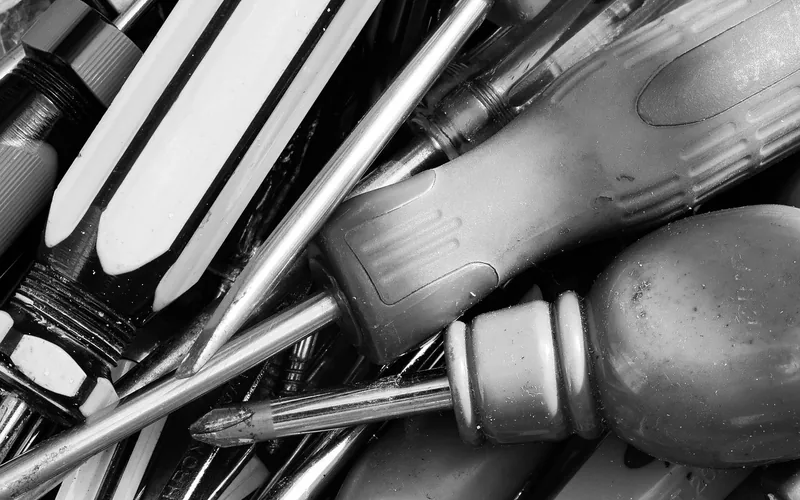 assorted screwdrivers and hand tools needed to replace a door handle