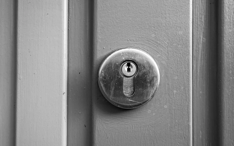 Close-up of a deadbolt cylinder lock and keyhole on a painted door Close-up of a deadbolt cylinder lock and keyhole on a painted door