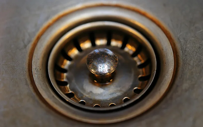 dirty rusty bathroom sink drain strainer in need of cleaning