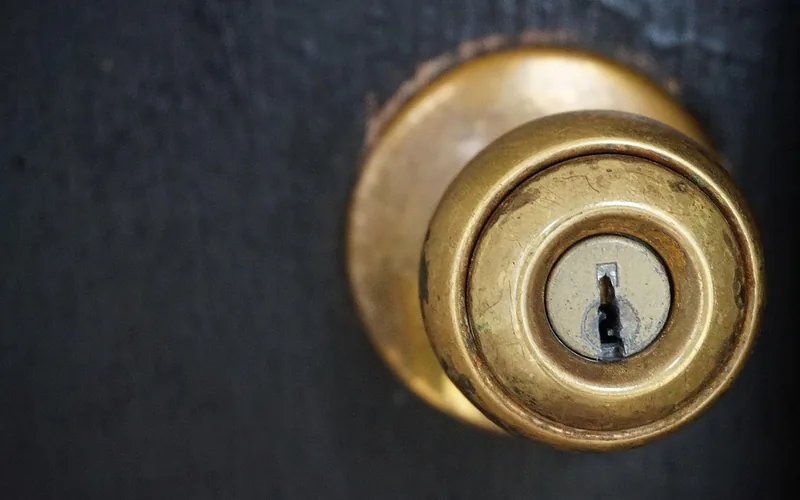 Close-up of a door knob and latch mechanism on a front door