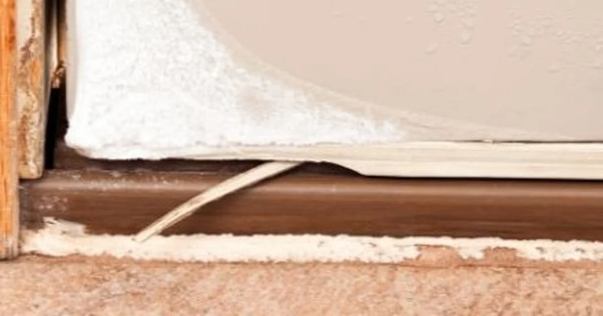 Worn door threshold seal gapping away from the frame before replacement