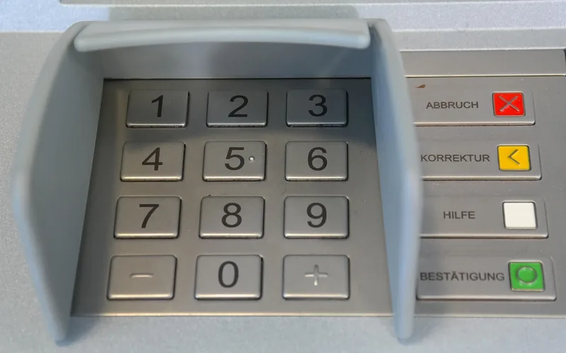 finger entering a code on an illuminated numeric keypad