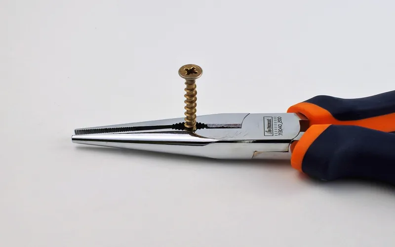needle-nose pliers gripping a stuck screw fastener