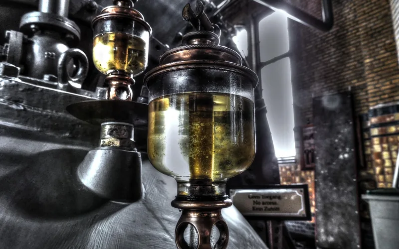 Oil can applying lubricant to a squeaky metal hinge