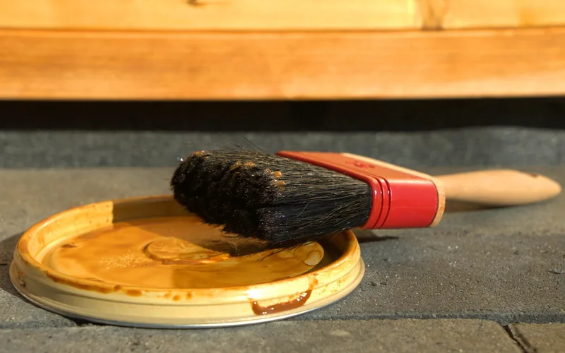 Paintbrush resting on a can lid, the brush-and-let-it-sit method used to apply paint stripper Paintbrush resting on a can lid, the brush-and-let-it-sit method used to apply paint stripper