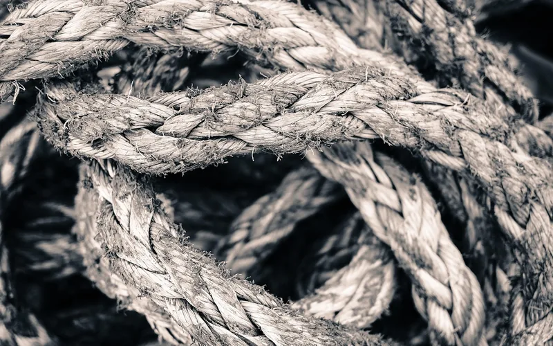 close-up of braided rope coiled and knotted, the type used to tension a tarp canopy