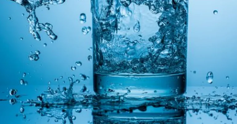 Clean water splashing in a glass, representing a freshly cleaned water softener system