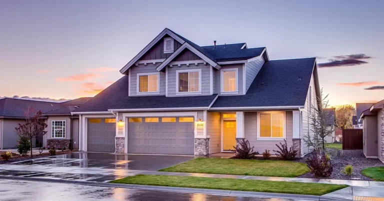 two-car garage door on a house exterior at dusk with lights on