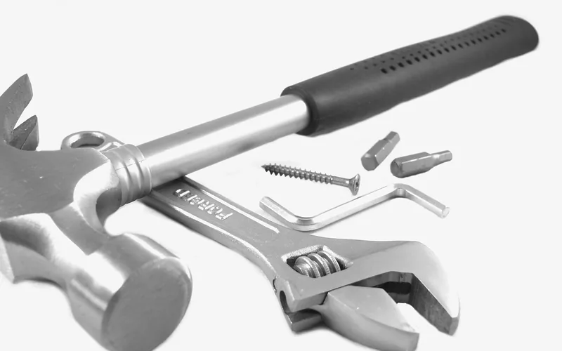 hammer, adjustable wrench, screws, and hex keys laid out as basic hinge-pin removal tools hammer, adjustable wrench, screws, and hex keys laid out as basic hinge-pin removal tools