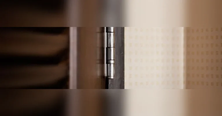 Self-closing door hinge mounted on a wooden door frame