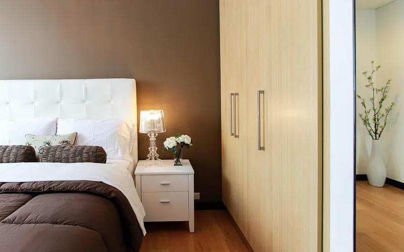 table lamp with a fabric-style shade glowing on a bedroom nightstand