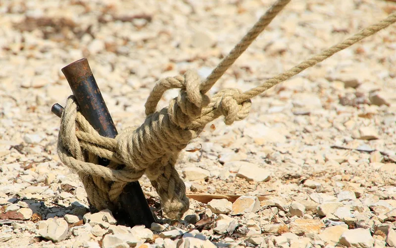 rope tied to a metal ground stake with a secure knot, used to anchor a canopy tent rope tied to a metal ground stake with a secure knot, used to anchor a canopy tent