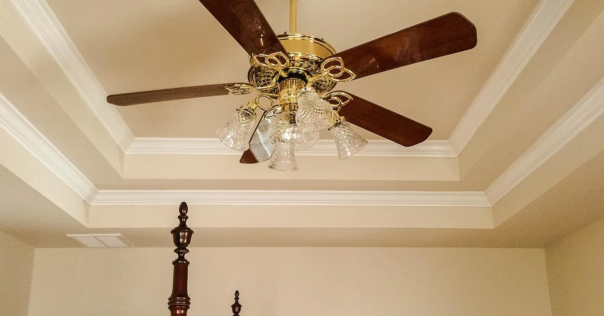 classic Hunter-style ceiling fan with wood blades and glass light globes mounted on a tray ceiling classic Hunter-style ceiling fan with wood blades and glass light globes mounted on a tray ceiling