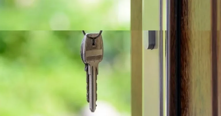 Key hanging near a door lock, illustrating how to lock the door in Spanish with a key