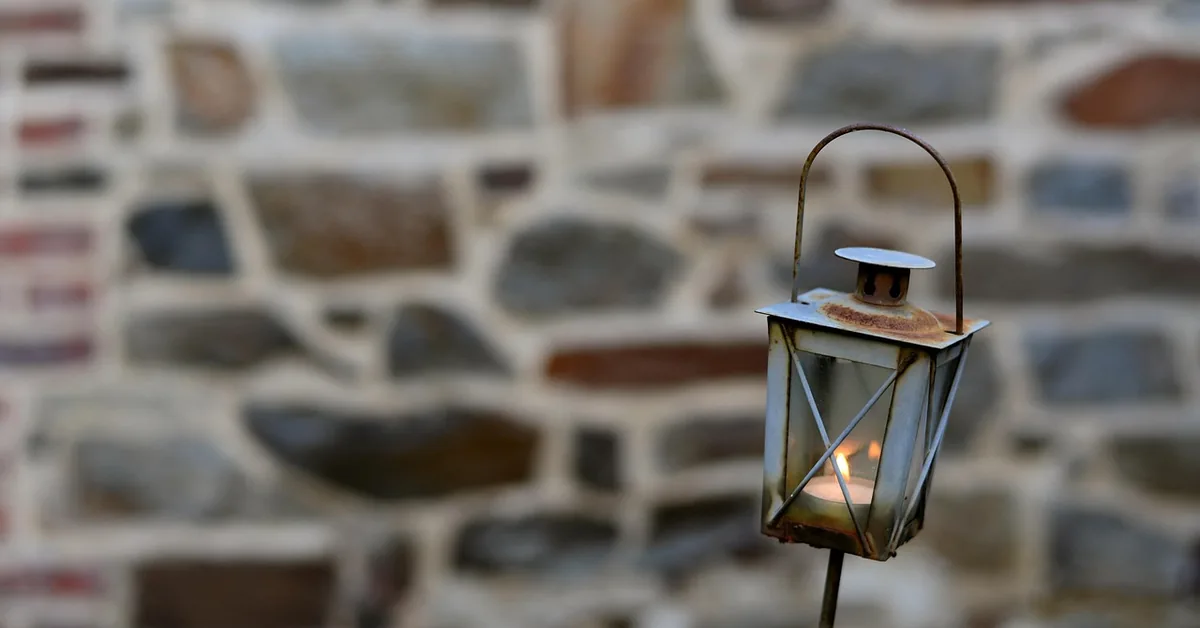 Rust spots forming on a metal light fixture cap where the protective coating has worn away