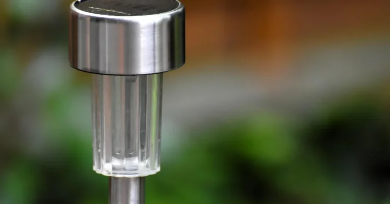 solar-powered garden stake light with panel absorbing daylight in a flower bed