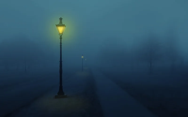 a street lamp glowing amber through thick night fog