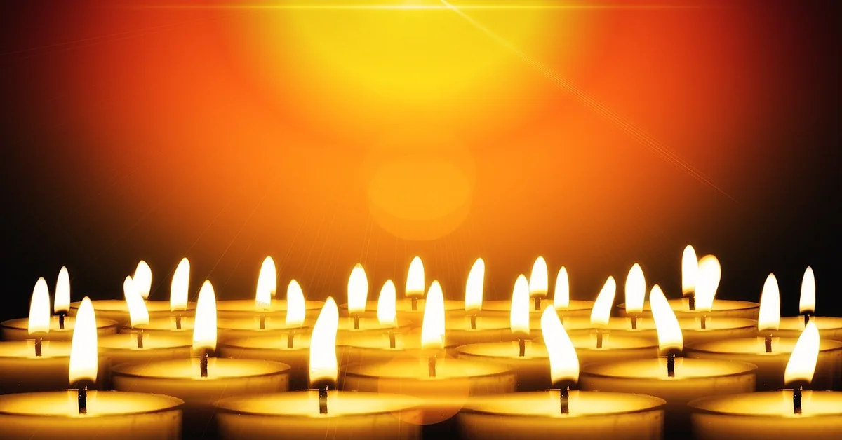 rows of lit tea light candles glowing close-up showing standard 1.5 inch size