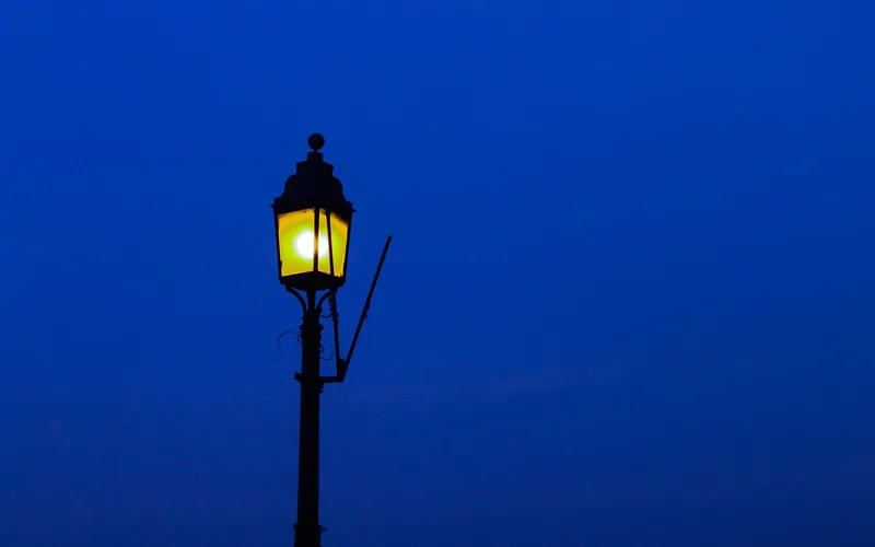 decorative black metal lamp post silhouetted against evening sky decorative black metal lamp post silhouetted against evening sky