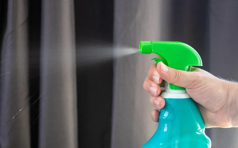 hand lightly misting a diluted disinfectant spray from a bottle hand lightly misting a diluted disinfectant spray from a bottle