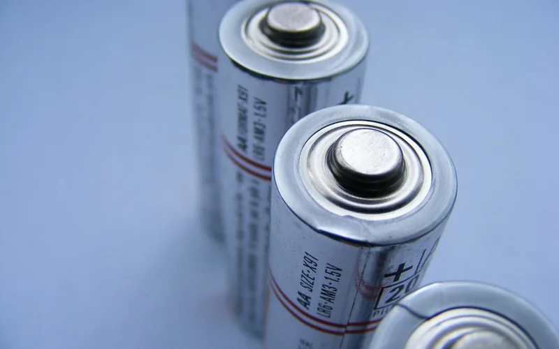 closeup of AA batteries showing the positive and negative terminal markings