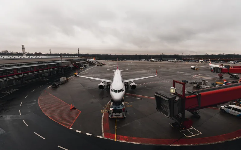 airline passenger jet parked at a terminal gate on a rainy tarmac