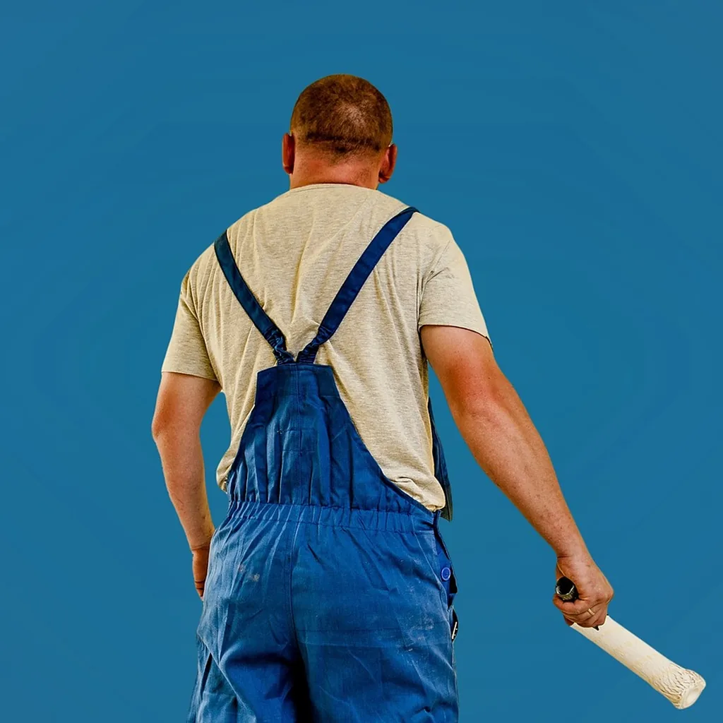 painter in coveralls holding a paint roller, back view painter in coveralls holding a paint roller, back view